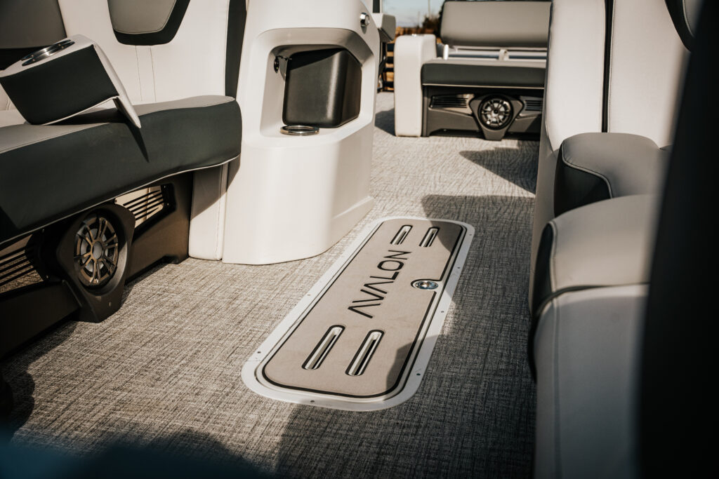 Interior view of 2026 Avalon LSZ boat featuring plush seating, Avalon branding on the floor, and stylish design elements, showcasing the boat's luxury and versatility.