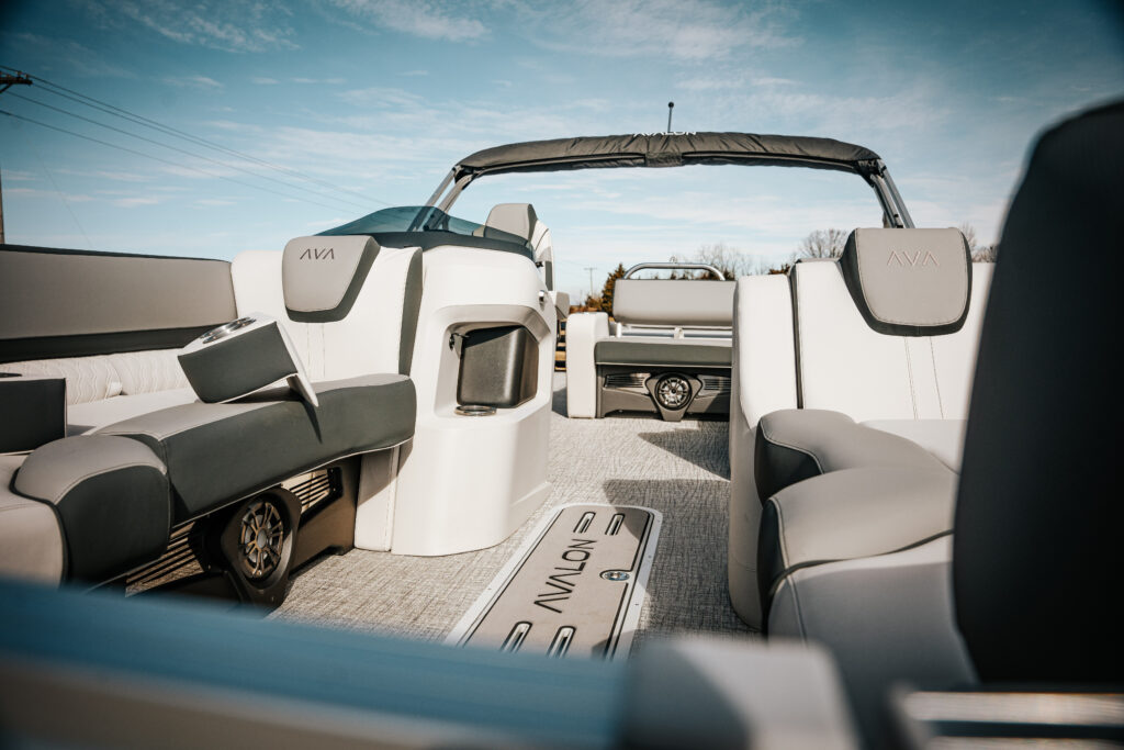 Interior view of the 2026 Avalon LSZ boat featuring plush seating in white and charcoal, detailed with Avalon branding, showcasing the spacious layout and modern design elements.