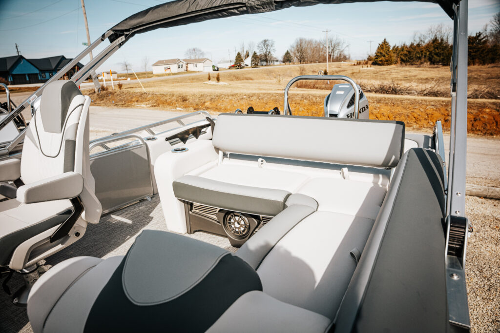 Interior seating of the 2026 Avalon LSZ boat, featuring versatile rear bench and sport high back reclining chair, with Honda motor visible in the background.
