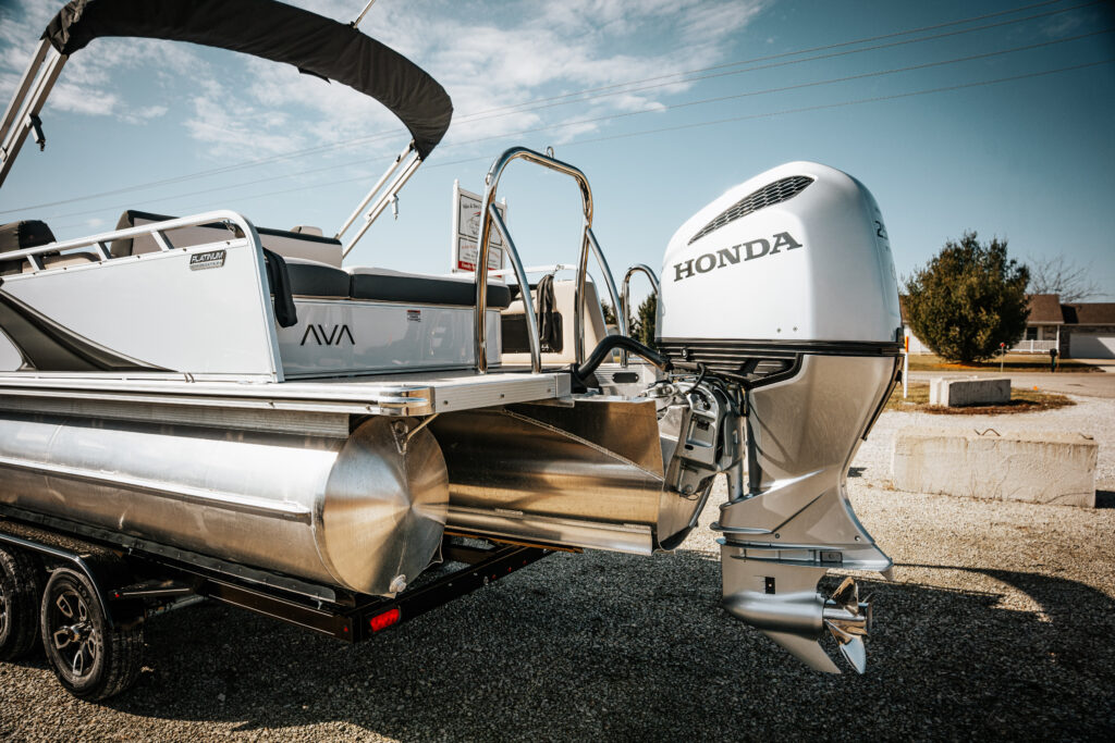 2026 Avalon LSZ boat in white with Honda outboard motor, showcasing sleek design and luxury features, parked on a trailer.