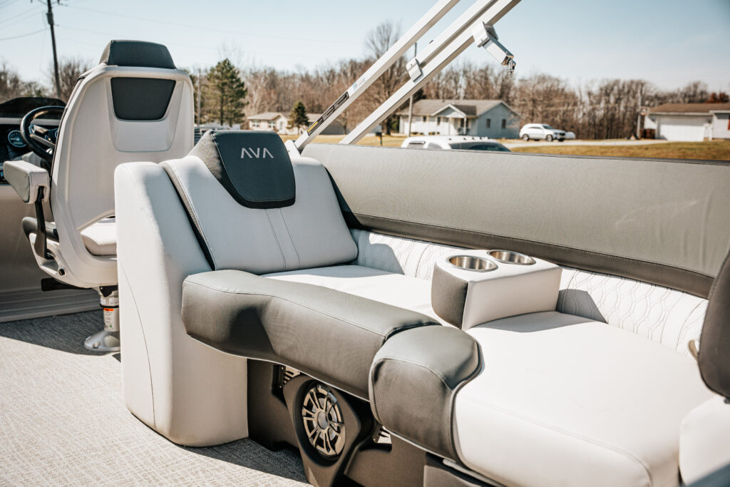 Interior seating of the 2026 Avalon LSZ boat featuring grey and white upholstery, high back reclining chair, and integrated cup holders, showcasing luxury and comfort for boating enthusiasts.