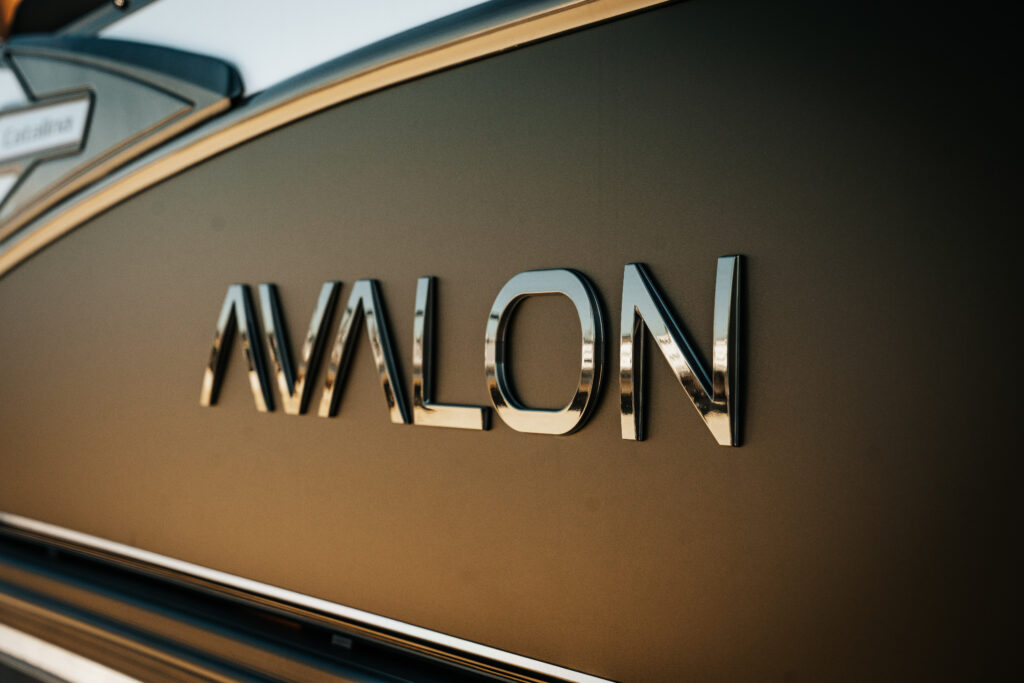 Avalon logo on the matte black exterior of the 2026 Avalon Catalina Quad Lounger, showcasing premium marine craftsmanship.