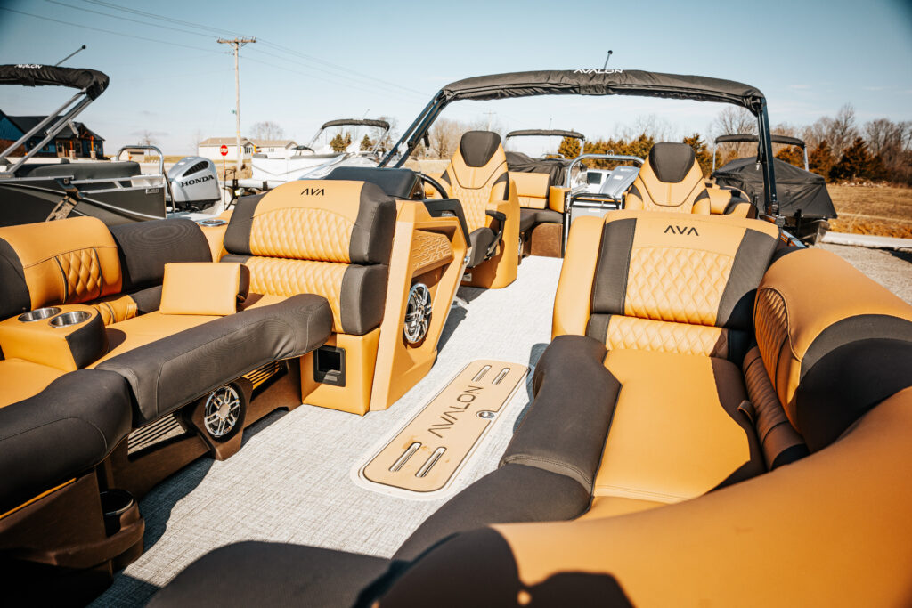 Interior view of the 2026 Avalon Catalina boat featuring luxurious black and orange seating, including high back reclining chairs, cup holders, and Avalon branding, highlighting premium design and comfort for boating enthusiasts.