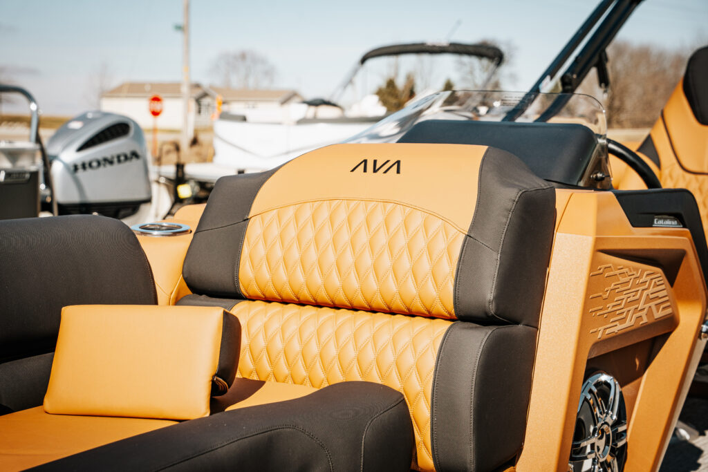 Avalon Catalina boat interior featuring plush, quilted seating in black and cognac, with the Avalon logo visible, alongside a Honda outboard motor in the background.