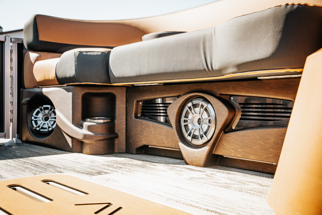 Interior detail of the 2026 Avalon LSZ boat showcasing plush seating, integrated audio speakers, and premium materials, emphasizing luxury and comfort in marine design.