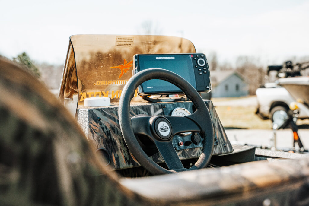 Boat dashboard featuring a steering wheel and a Humminbird fish finder, showcasing advanced navigation and fishing technology for the 2024 Polar Kraft Sport X 190 SC.