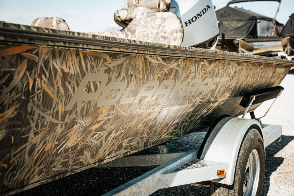 Polar Kraft boat with camouflage design and Honda motor, showcasing brand name and trailer details.