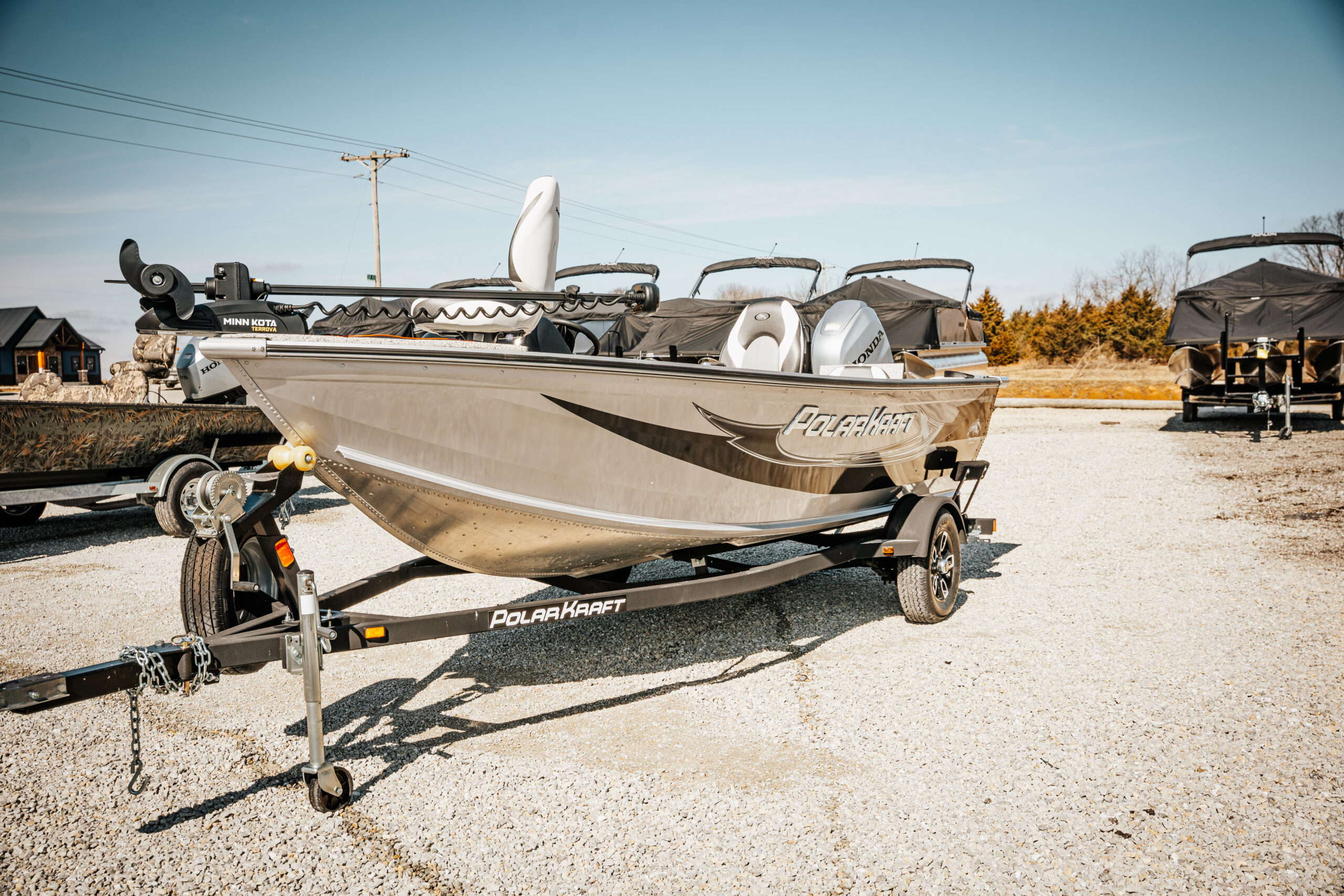 2024 Polar Kraft Frontier 165 SC boat displayed on a trailer in a marine inventory lot, showcasing its sleek design and seating arrangement.