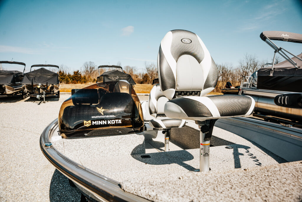 Fishing boat featuring upgraded seating and Minn Kota motor, showcasing Humminbird technology, with additional boats in the background.