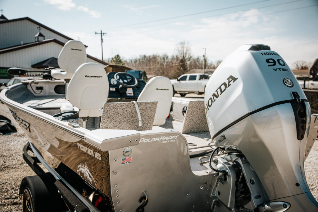 2024 Polar Kraft Frontier 165 SC boat with 90 HP Honda motor, featuring upgraded fishing seats and a modern dashboard, set against a sunny outdoor backdrop.