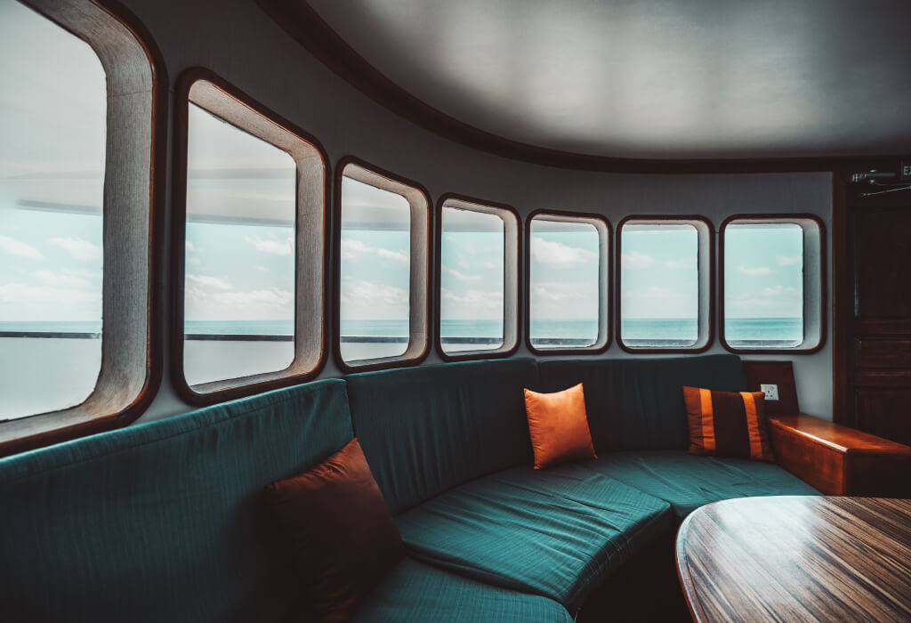Luxury yacht interior with large windows and comfortable seating